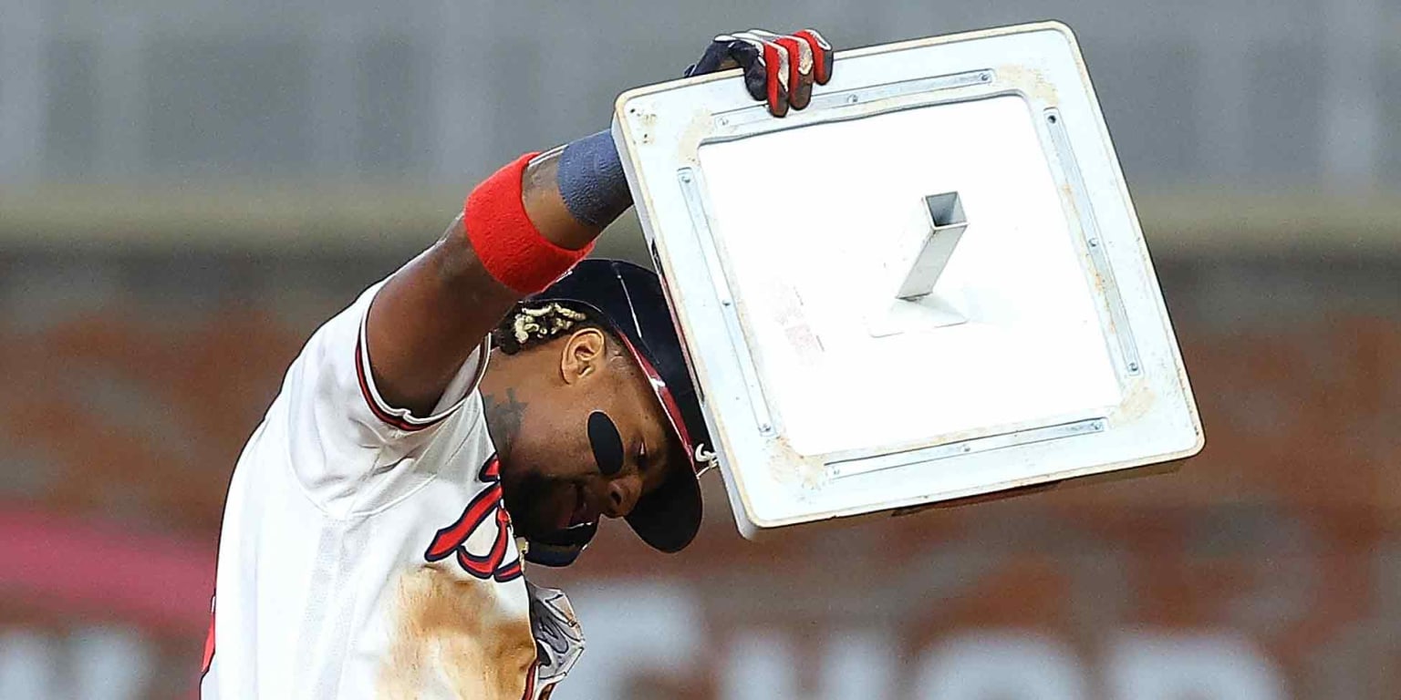 Ronald Acuña Jr. holds up a base after reaching 70 stolen bases during his historic 2023 season